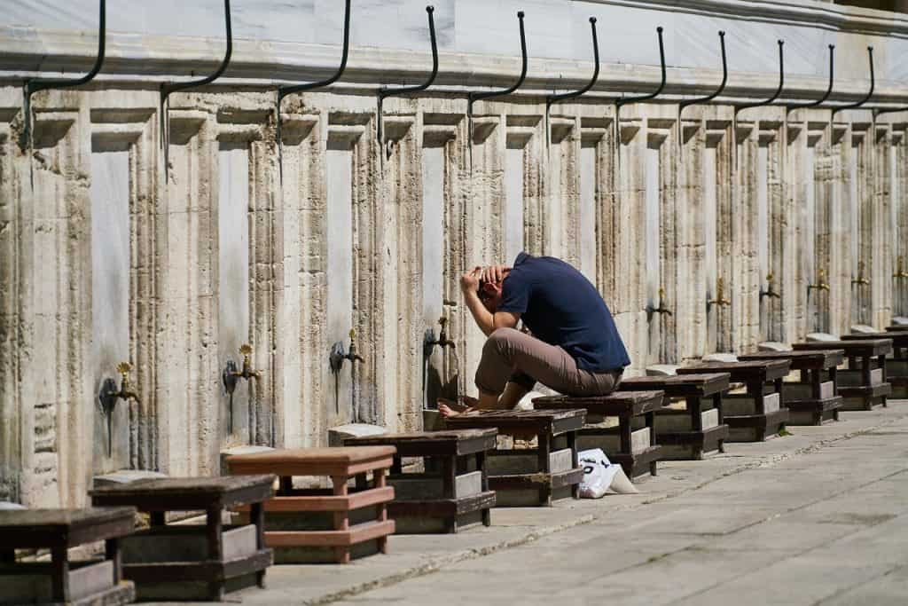 muslim man performing wudu at mosque